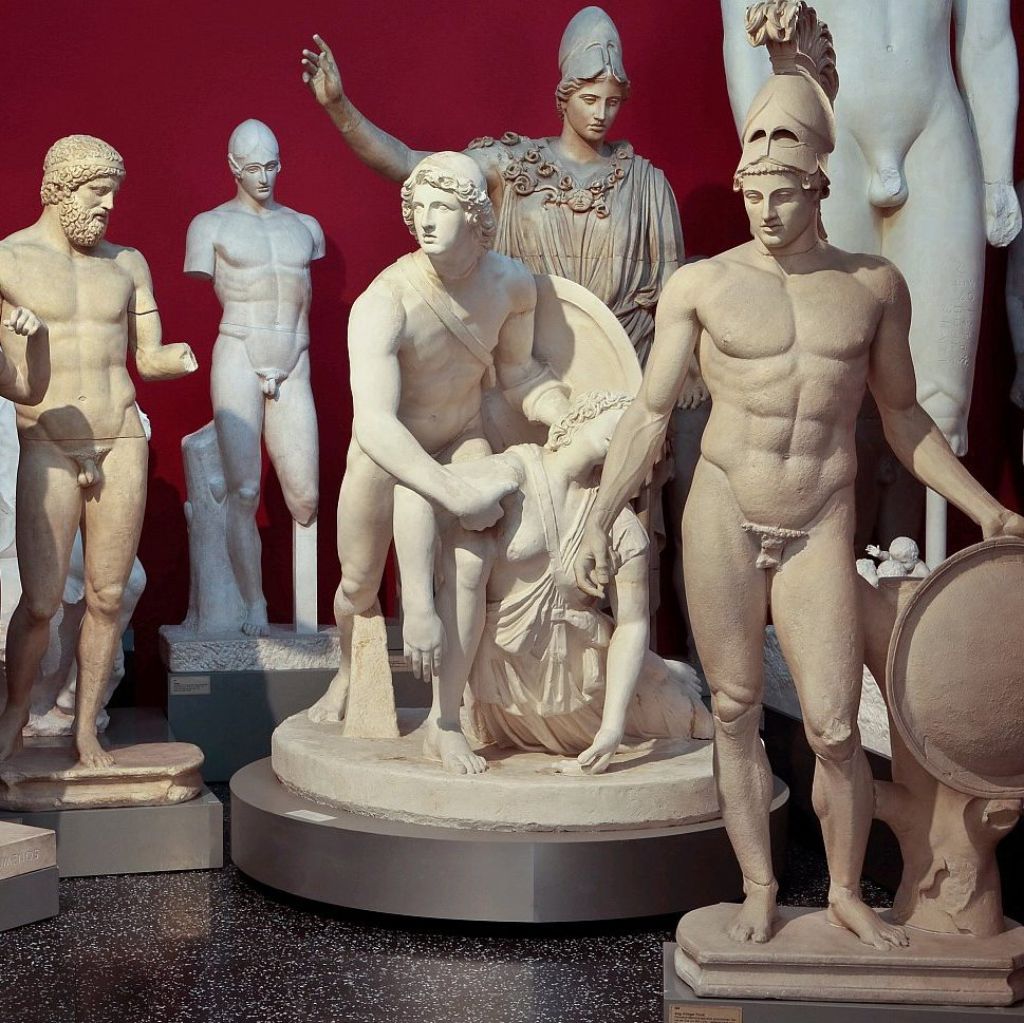 Plaster sculptures grouped in front of a red wall