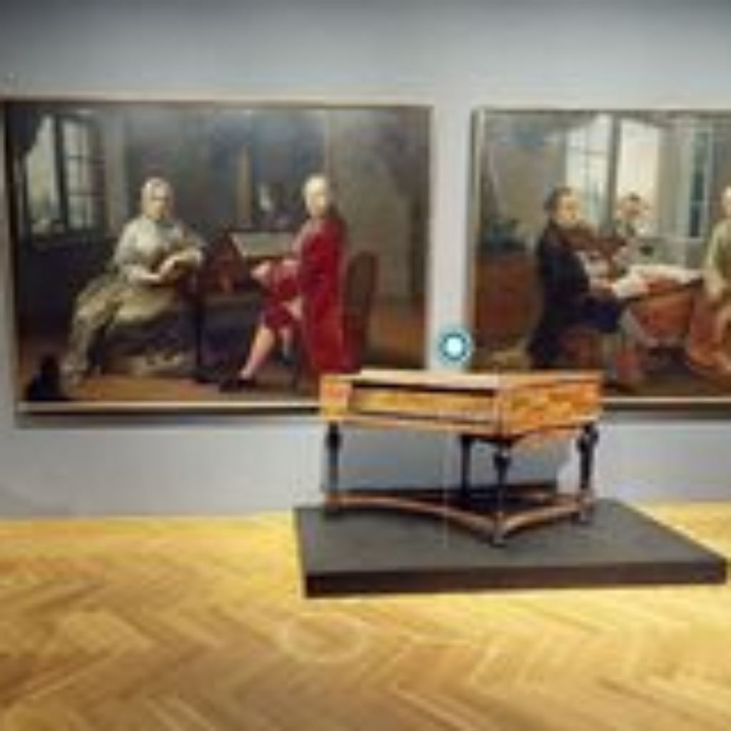 Piano with two paintings in the background.