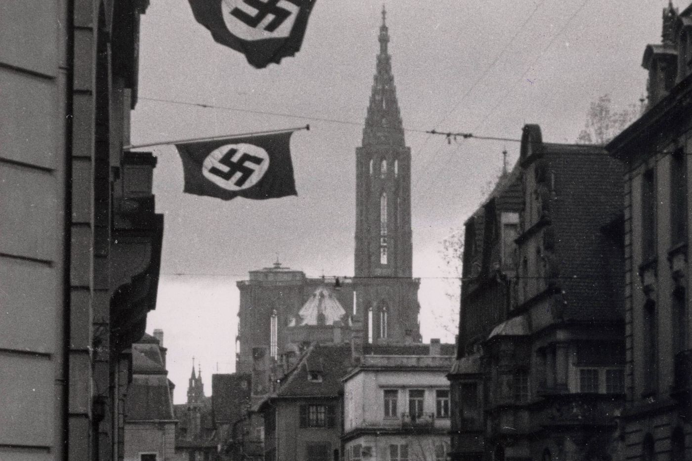 Une rue historique avec des bâtiments au premier plan et une cathédrale en arrière-plan
