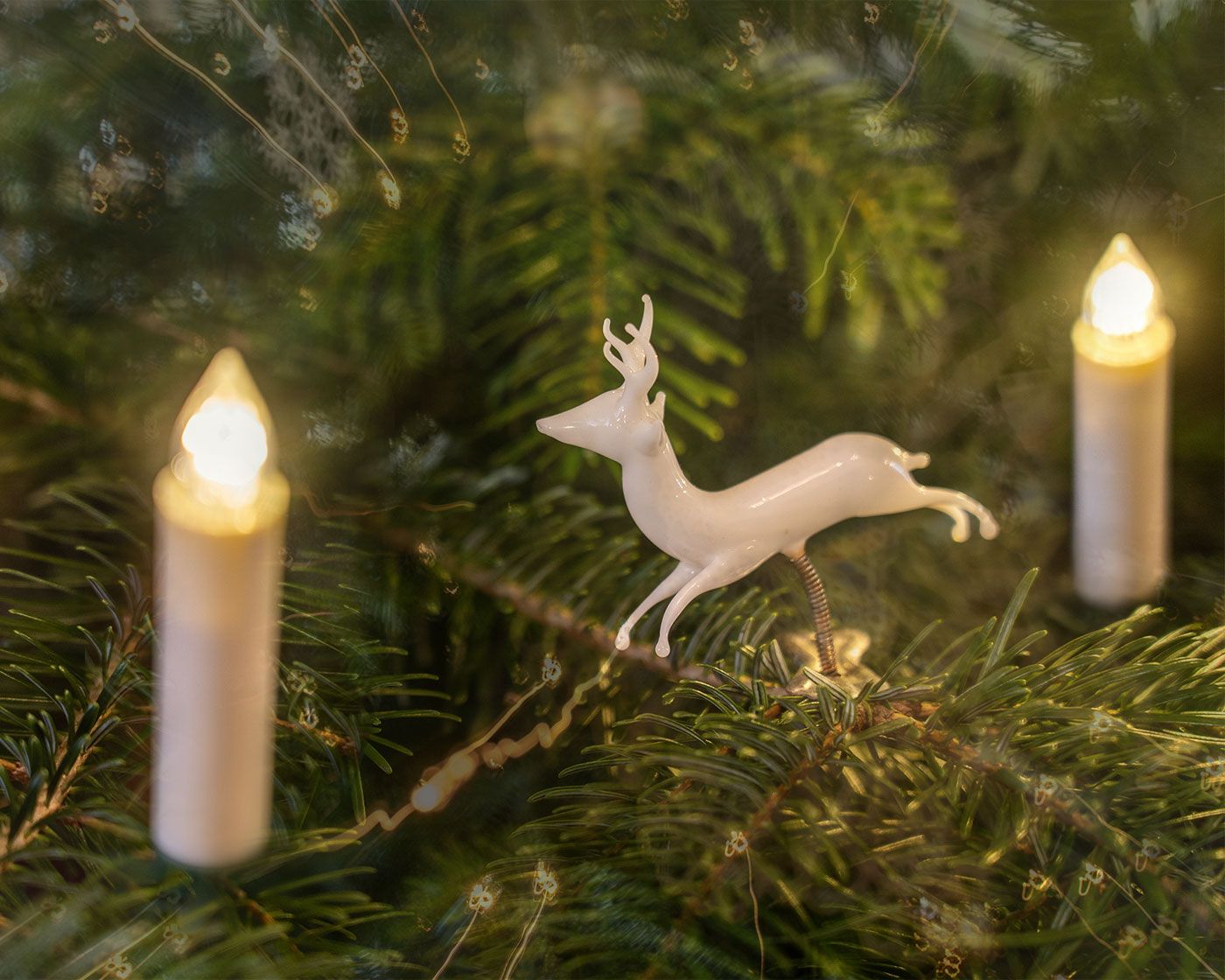Eine geschwungene Holztreppe mit kunstvoll verziertem Eisen-Geländer im halb dunklen Licht