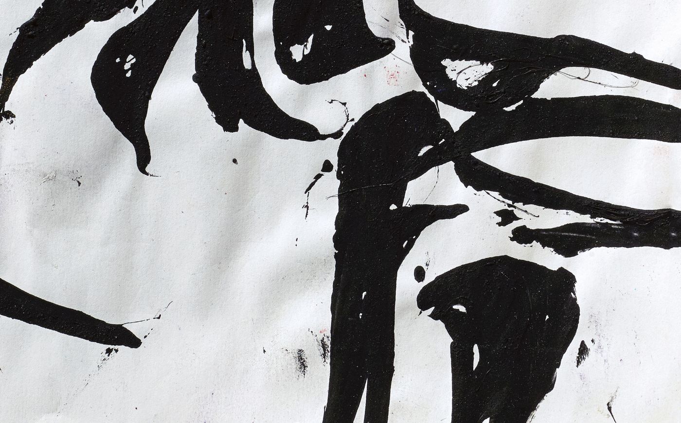 Schwarze Pinselstriche formen abstrakte Muster auf weissem Papier