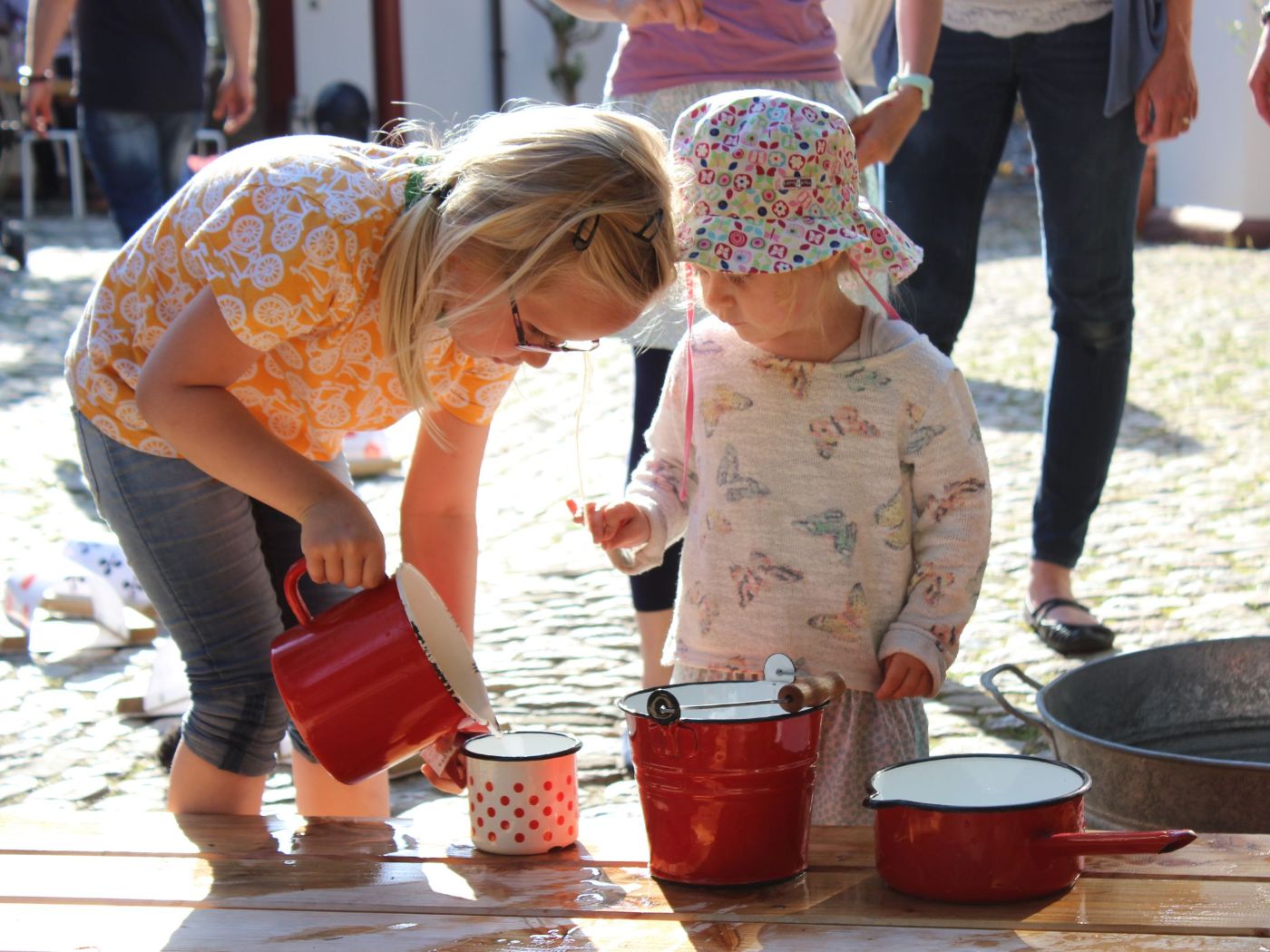 Kinder spielen im Museumshof mit Wasser 