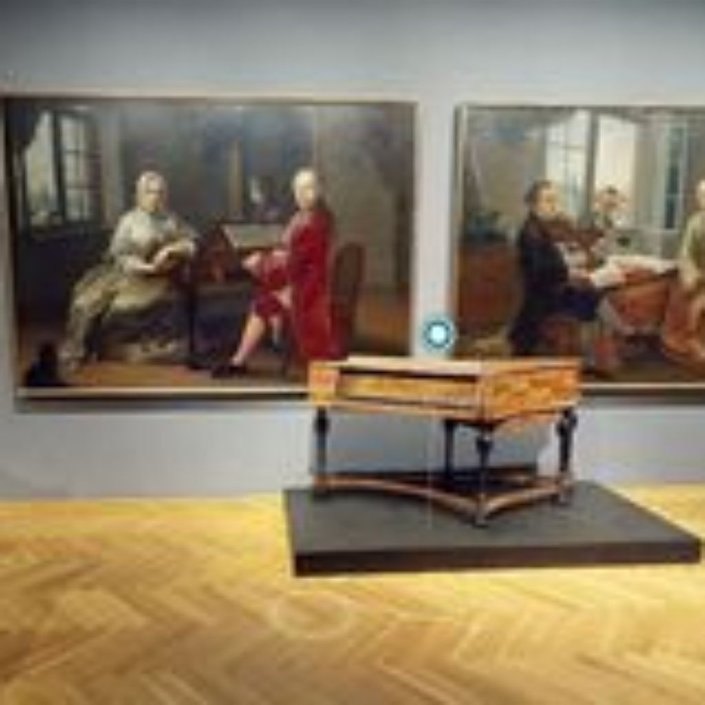 Klavier mit zwei Gemälden im Hintergrund.